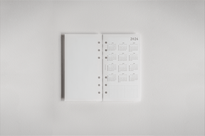 Clean white 2026 dated planner inserts featuring organized monthly grids and pre-punched holes for effortless binding into a daily planner.
