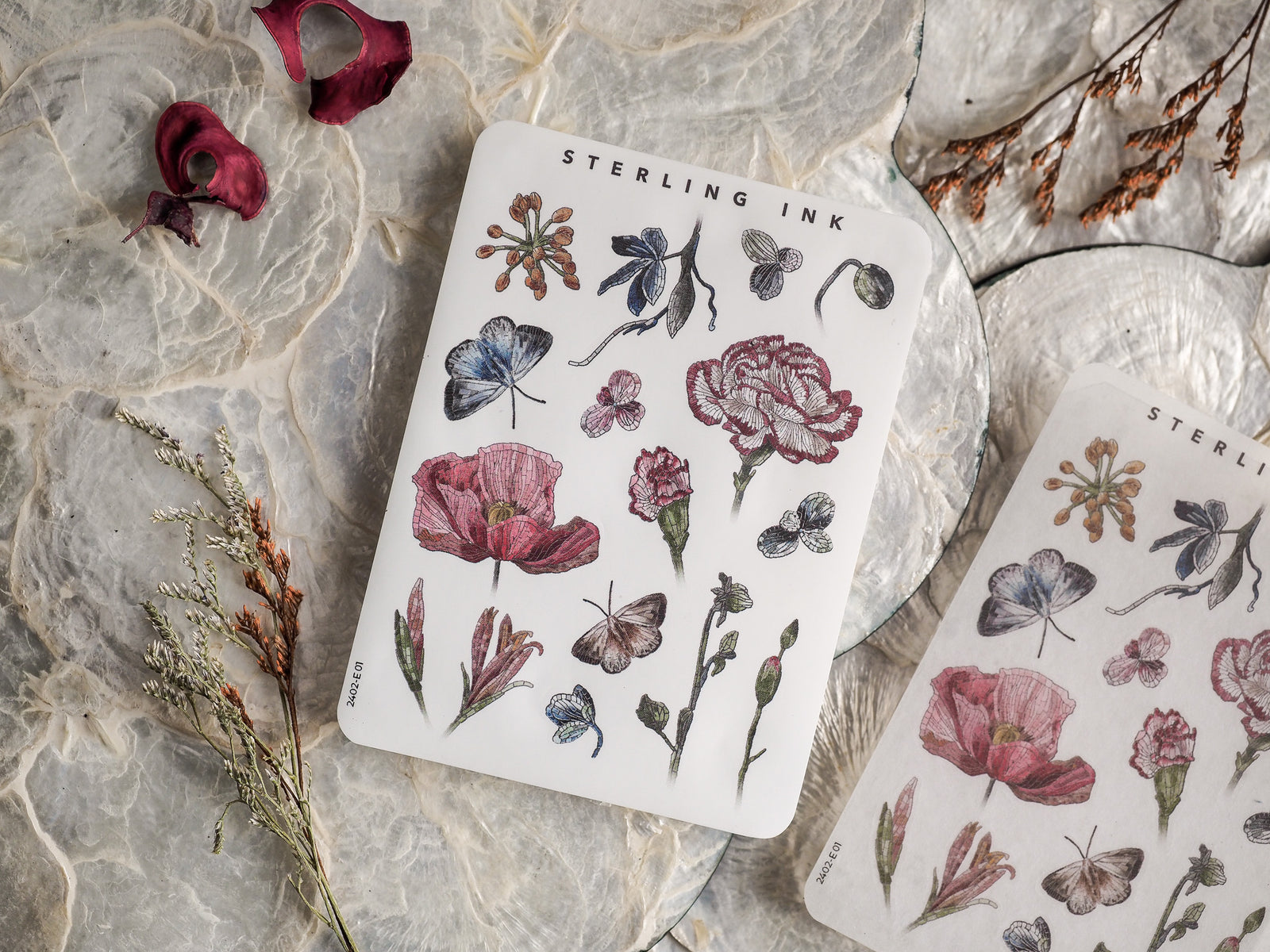 Intricate botanical elements sticker sheet featuring line drawings and soft watercolor washes of lush flowers, leaves, and butterflies.