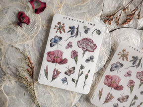 Intricate botanical elements sticker sheet featuring line drawings and soft watercolor washes of lush flowers, leaves, and butterflies.