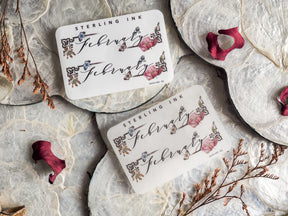 Ornate planner sticker set for February featuring delicate, scripted "February" lettering and detailed floral embellishments on an off-white background.