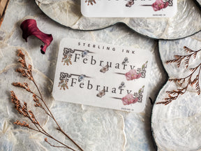 A sophisticated sticker displaying "February" framed by romantic watercolor florals, delicate vines, and elegant script lettering.