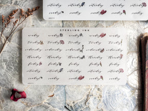 Elegant sticker sheets for February 2024, featuring week days printed in sophisticated watercolor calligraphy and adorned with delicate red botanical accents for planning.