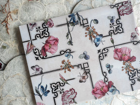 Elegant February 2024 planner spread featuring detailed black geometric borders framing soft watercolor illustrations of pink and blue flowers and delicate butterflies.