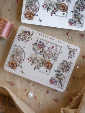 Elegant corner stickers featuring detailed, muted botanical illustrations with clusters of rustic flowers and delicate silver foil accents.