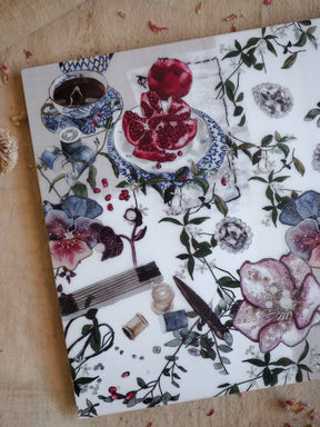 Vellum paper for February 2025 adorned with a rich botanical pattern of red berries, teacups, and detailed watercolor floral illustrations.