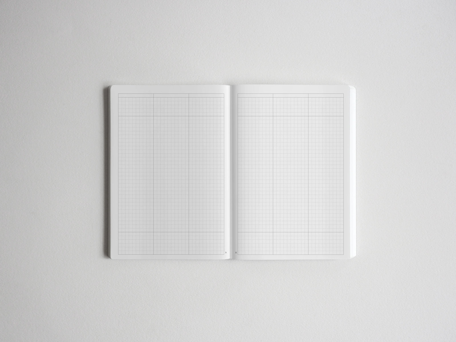 Open spiral sketchbook displaying pristine graph paper grids, ideal for technical drawing, precise journaling, or architectural planning.
