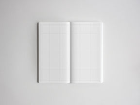 Open notebook displaying white graph paper grids on both pages, ideal for drawing, sketching, or technical planning.