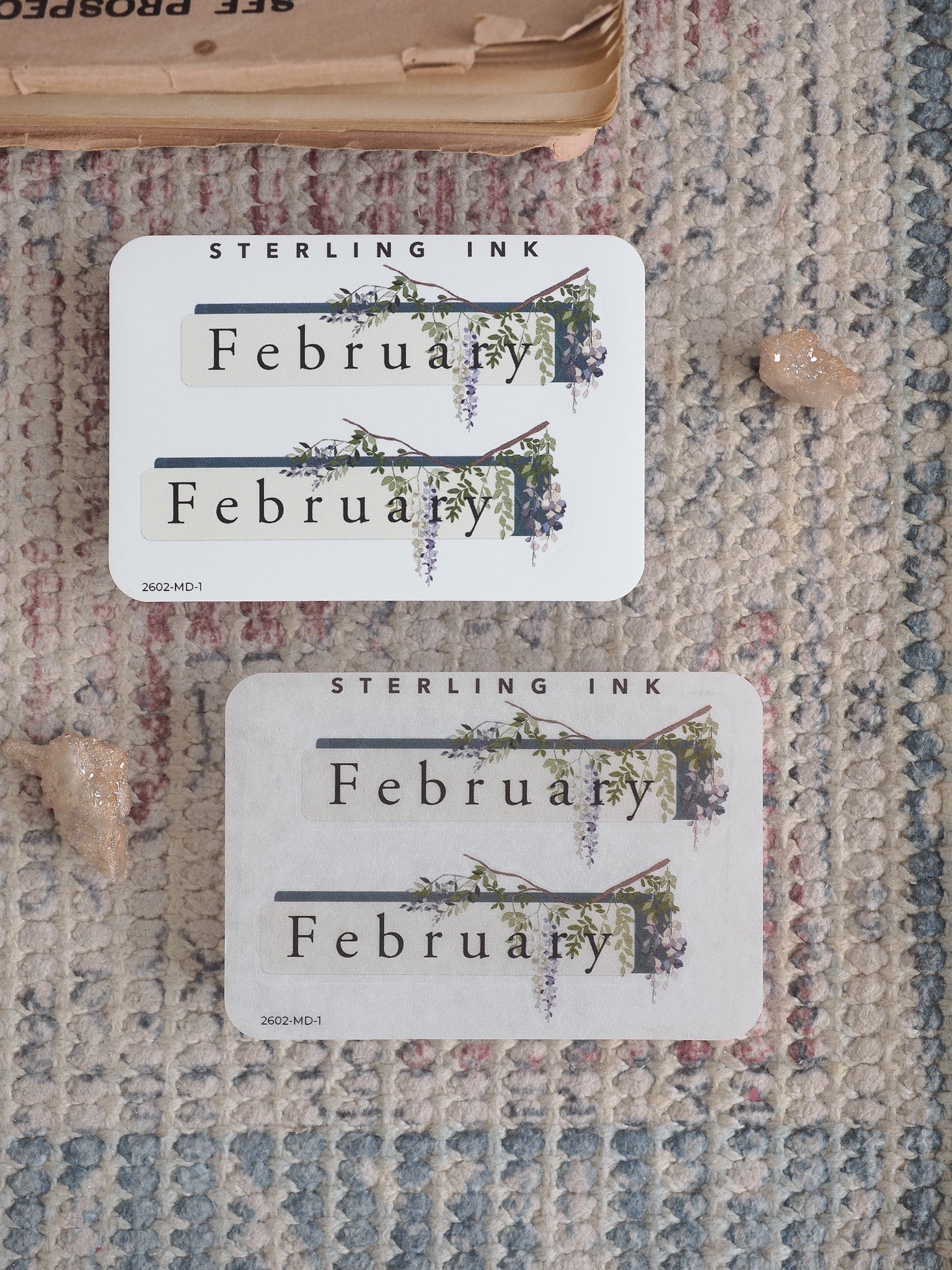 A set of coordinating stickers featuring the word "February" and delicate botanical vine illustrations printed on light cream paper.