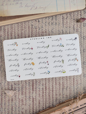 A delicate, white sticker sheet designed for planners, featuring seven days of the week each adorned with small, hand-drawn botanical accents and floral motifs.