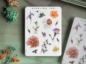 Watercolor sticker elements featuring a rich collection of botanical illustrations, including deep purple irises, blush peonies, and bright orange blooms.