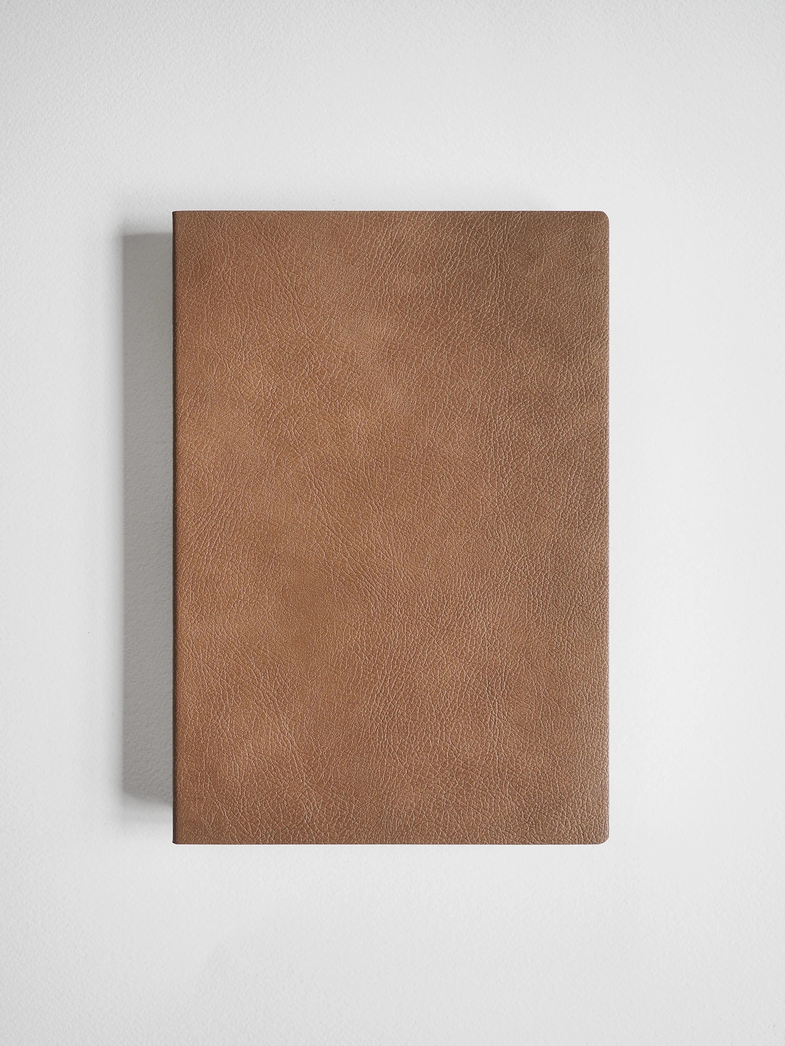 A brown textured leather notebook or journal cover shown flat against a light gray background.
#Color_Caramel