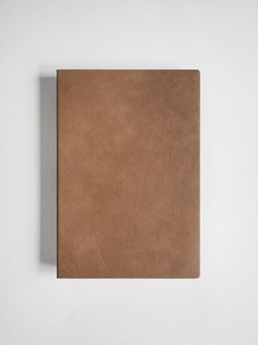 A brown textured leather notebook or journal cover shown flat against a light gray background.
#Color_Caramel