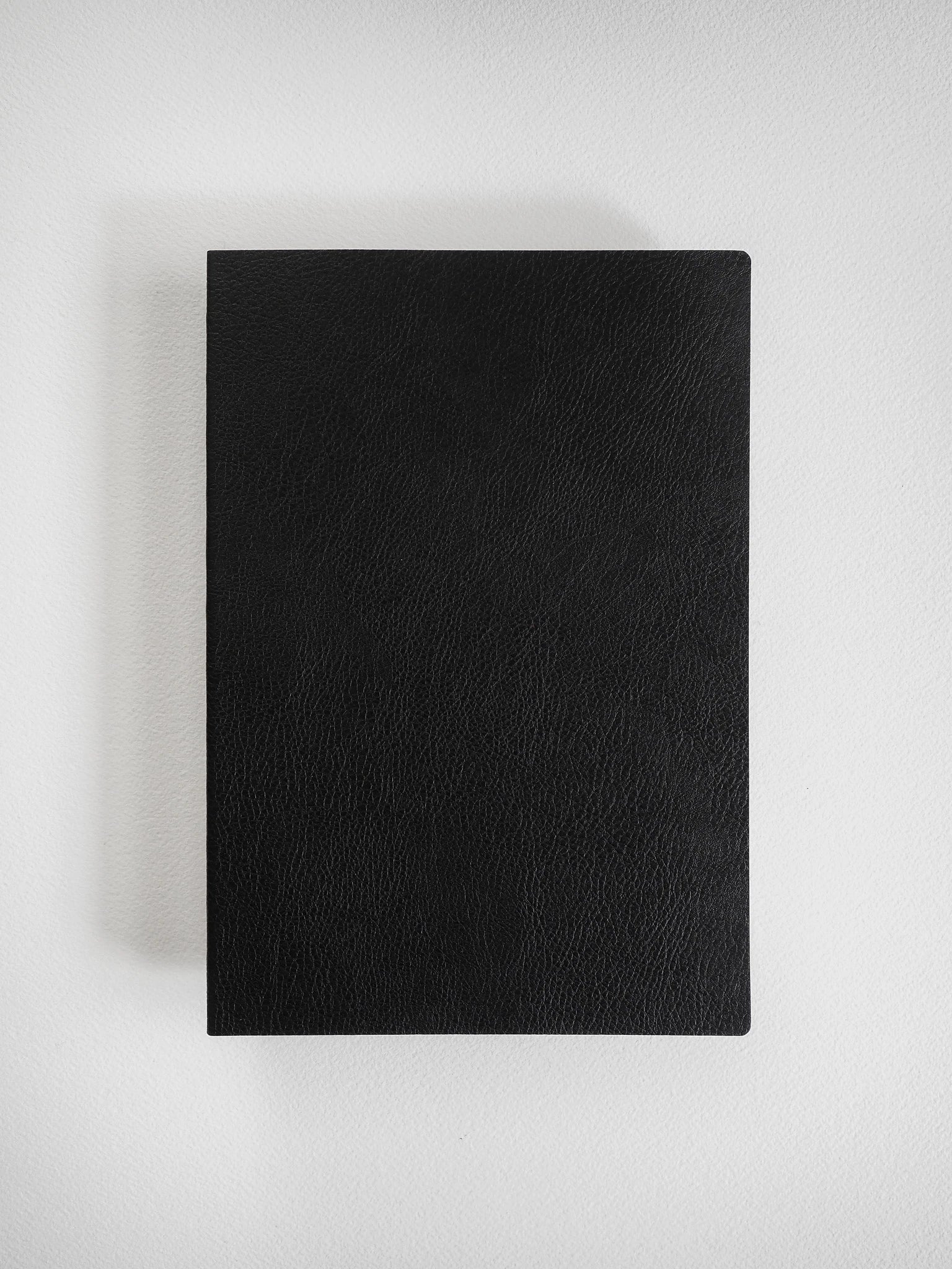 A black textured leather or faux-leather rectangular case or book cover, shown closed from a top-down view on a light gray background.
#Color_Onyx