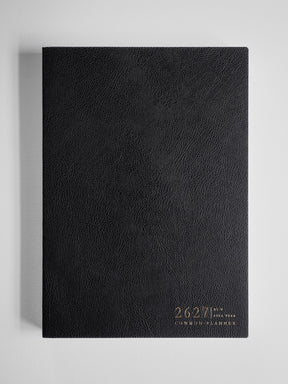Sleek black academic planner featuring a textured, faux leather cover and elegant gold foil text displaying "2026-2027 Common Planner."