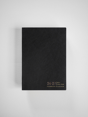 Minimalist black academic planner featuring a textured faux-leather cover and elegant gold foil text announcing the 2026-2027 school year and "Common Planner."