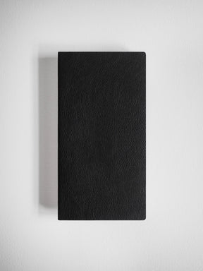 A black textured leather notebook or journal with a rectangular shape, shown from a top-down perspective on a light gray background.
#Color_Onyx