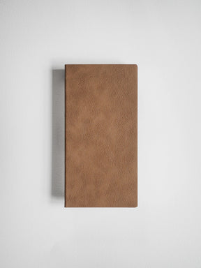 A brown textured leather or faux-leather rectangular case standing upright against a light gray background.
#Color_Caramel