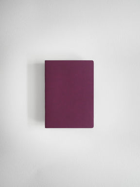 A minimalist, solid dark purple notebook or journal with rounded corners, centered against a clean, light gray textured background.
#Color_Mulberry