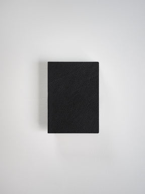 A black textured leather notebook or journal with a rectangular shape, shown from a top-down perspective on a light gray background.
#Color_Onyx