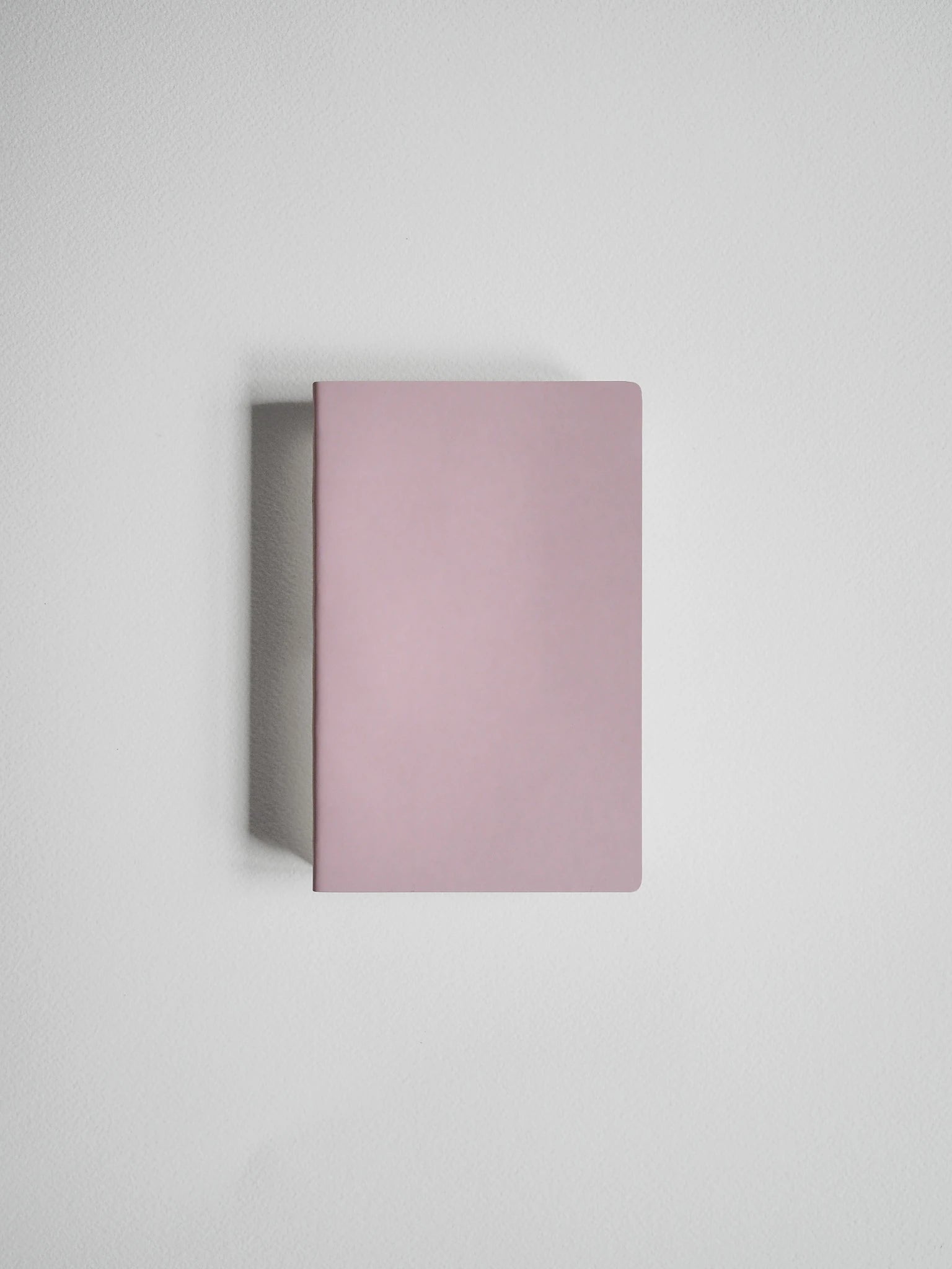 A minimalist, rectangular notebook or journal with a matte dusty pink cover, shown from a top-down perspective on a light gray background.
#Color_Fairyfloss