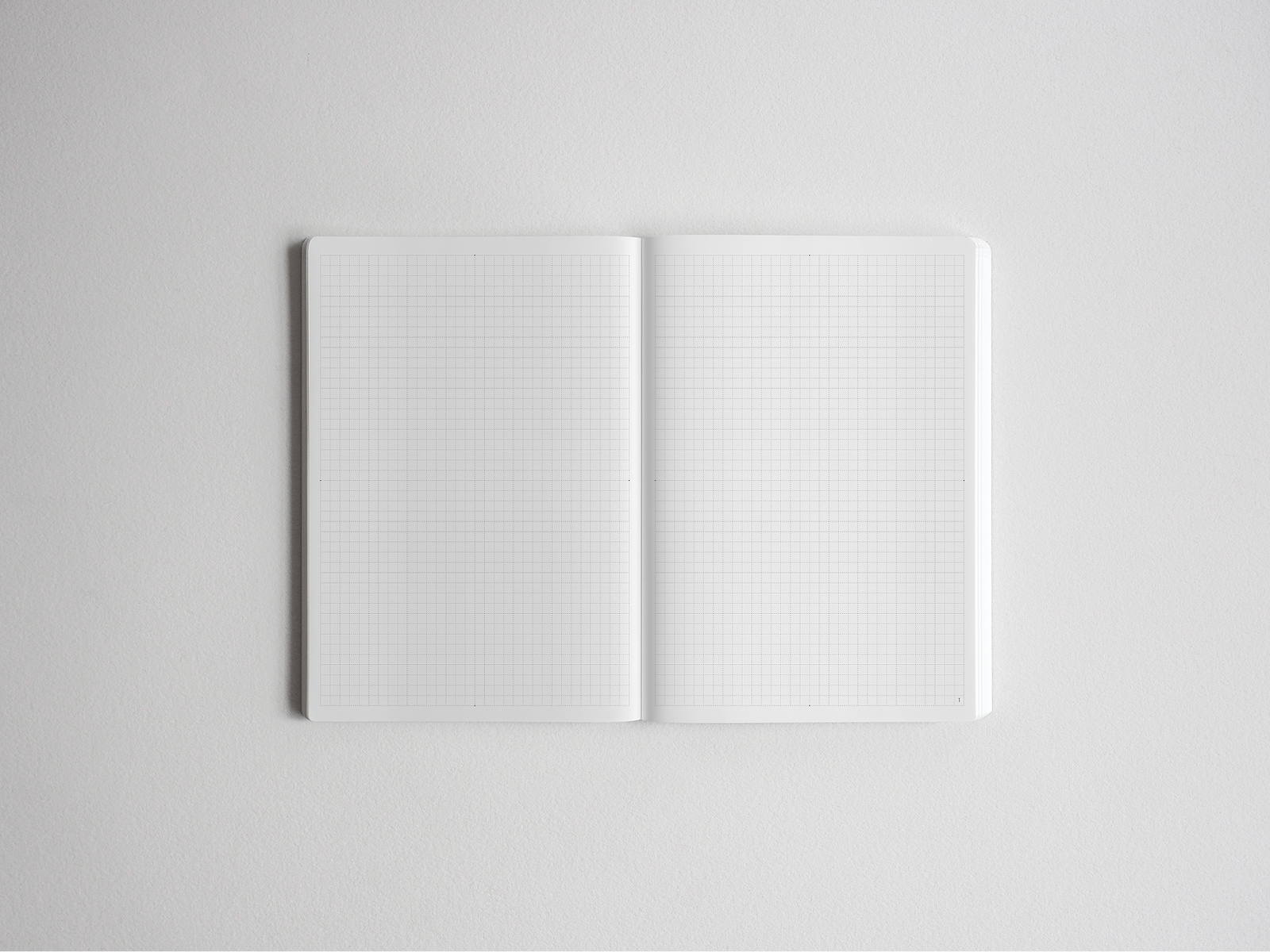 An open B6 notebook displaying fine, light-gray graph paper lines across both pages, perfect for academic plotting, grid drawing, or organized note-taking.