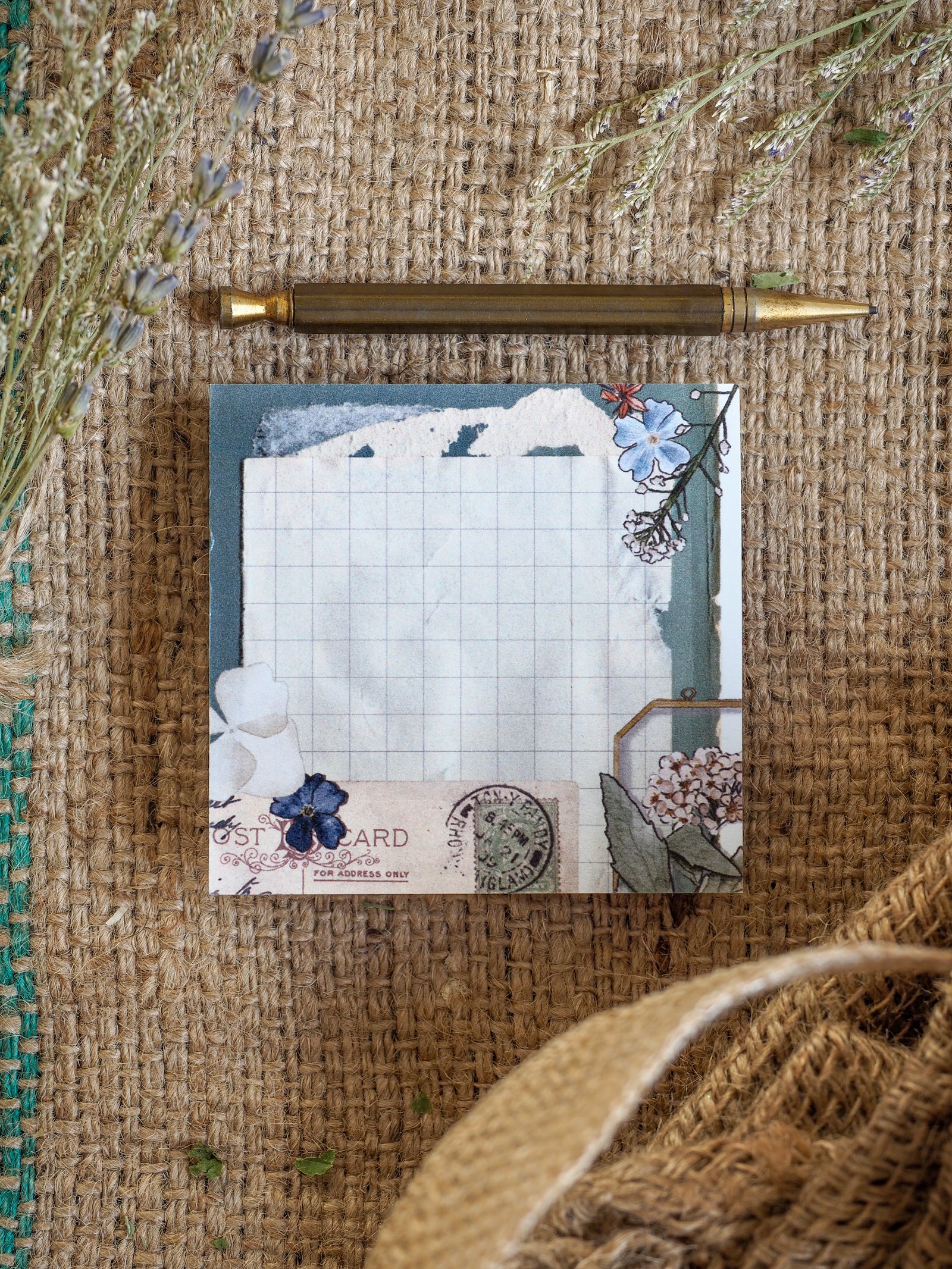 Botanical note featuring a clean grid background and charming watercolor clusters of blue and white pressed flowers.