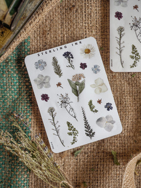 Detailed sticker sheet featuring an array of botanical elements, including wildflowers, delicate foliage, and butterflies, rendered in natural, illustrative tones.