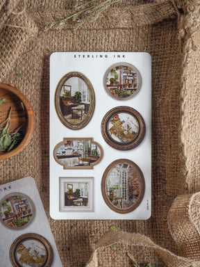 Assortment of die-cut stickers featuring vintage picture frames displaying various rustic scenes, including cozy interiors, potted plants, and antique-style artwork.