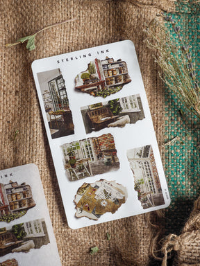 A sheet of "Torn Paper Stickers - March 2025" featuring vintage, distressed images of various architectural storefronts and urban settings.