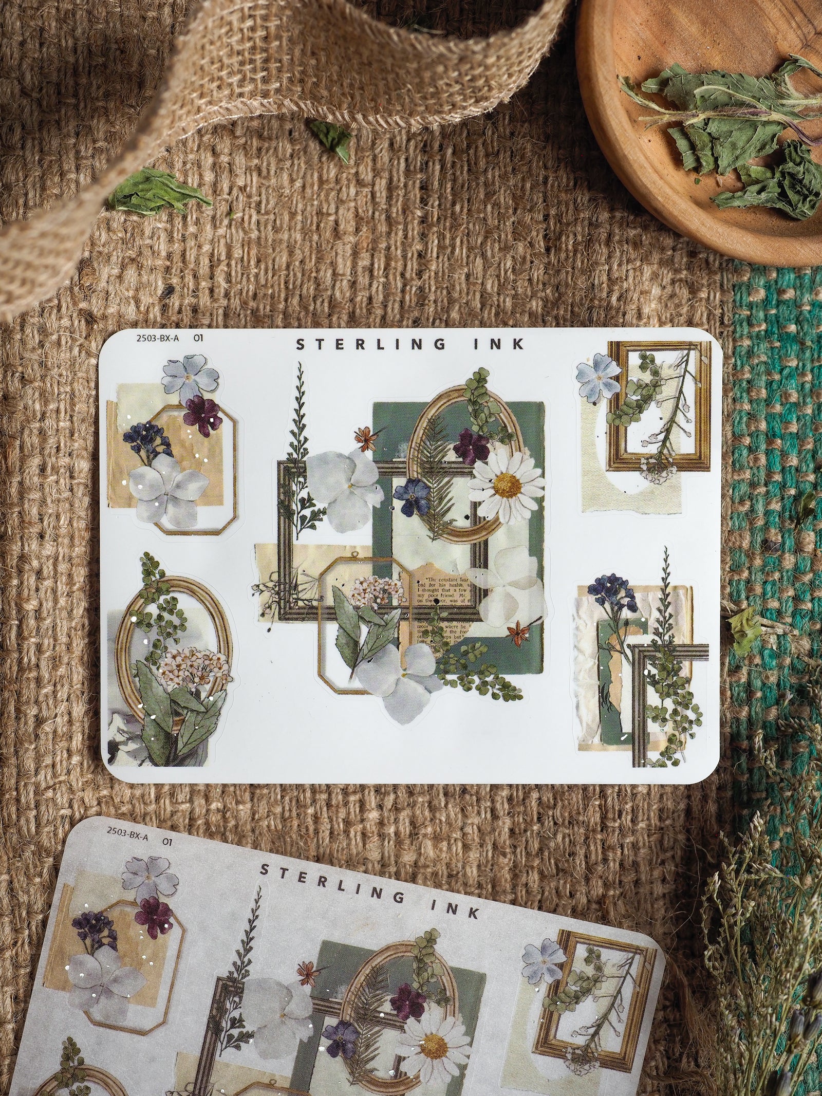 Elegant botanical sticker sheet with silver foil edges and corners, featuring delicate watercolor wildflowers and muted greenery designs perfect for journaling.