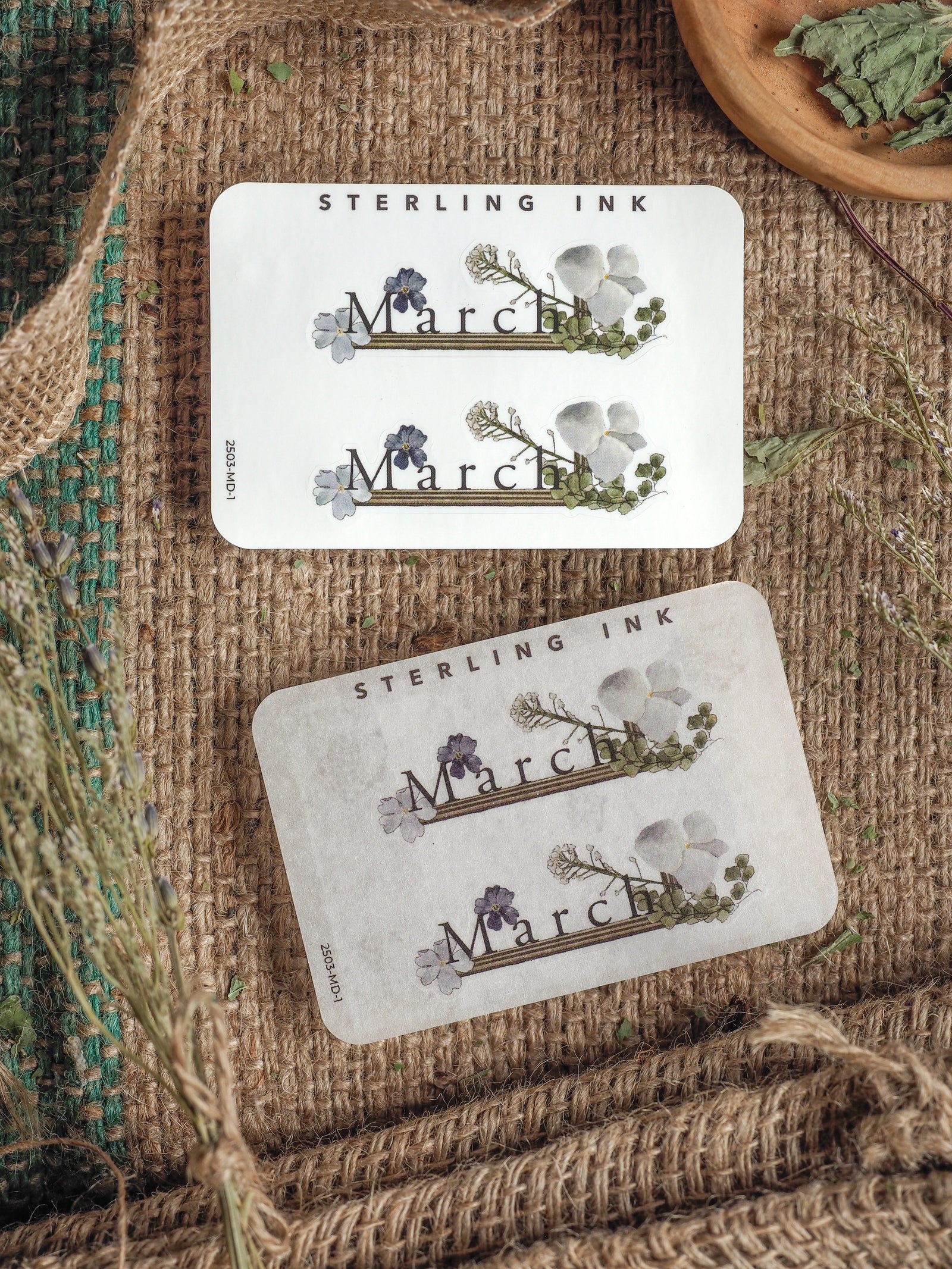 Decorative "March" month stickers featuring delicate watercolor floral clusters and elegant typography on clean white cardstock.