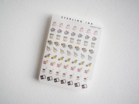 Whimsical sticker sheet featuring pastel houses, decorative pots, gold accents, and assorted detailed objects, perfect for