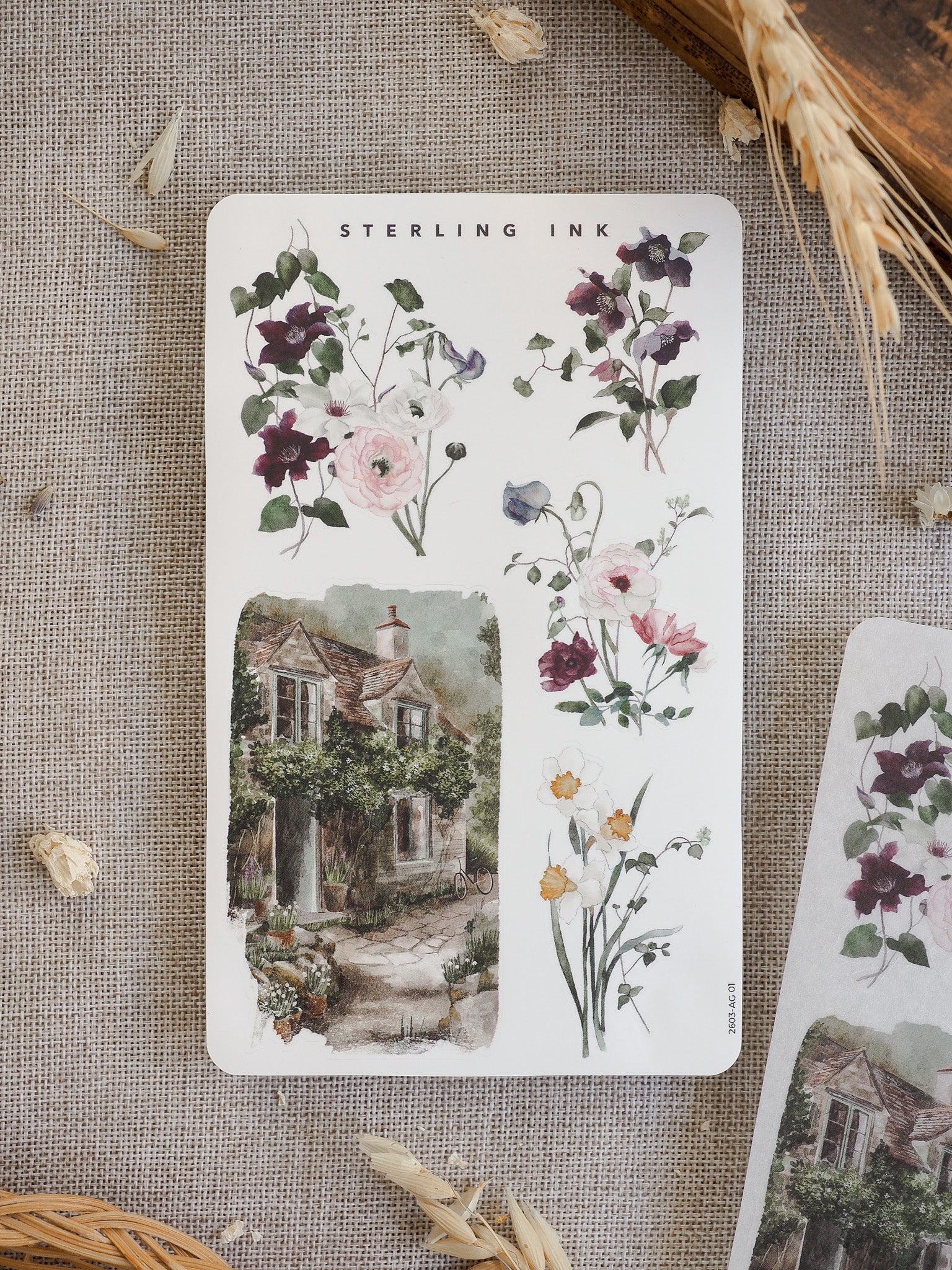 Spring arrangement stickers featuring delicate watercolor bouquets of purples and blush pinks, alongside a picturesque illustration of a mossy, rustic stone cottage.