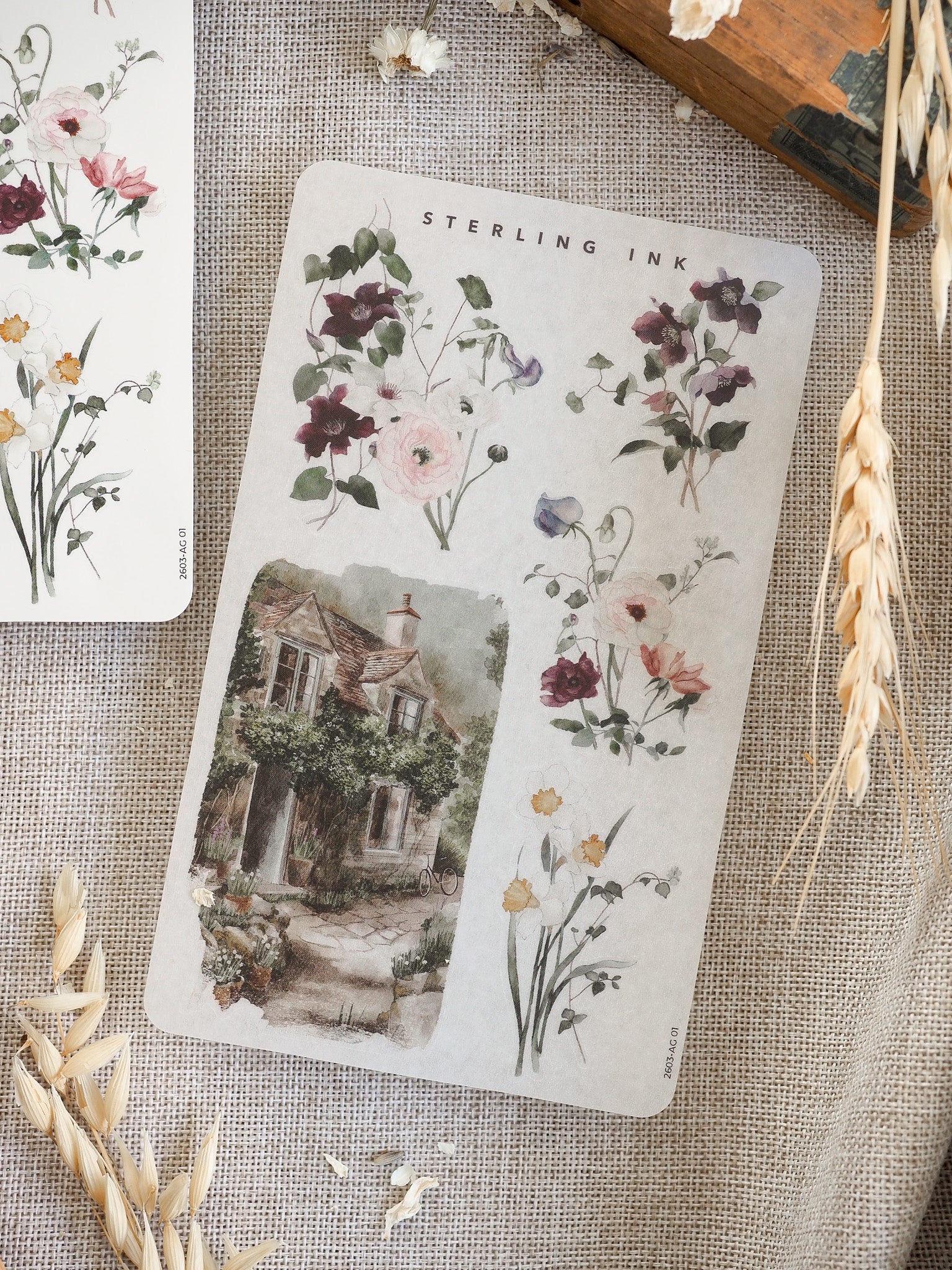 Delicate sticker sheet featuring watercolor spring florals and bouquets arranged alongside a charming, detailed sketch of an English cottage.