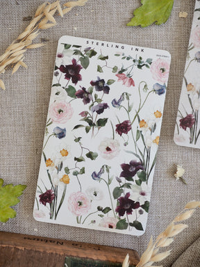 Delicate floral sticker strip featuring detailed watercolor clusters of deep purple, blush pink, and white peonies and surrounding green foliage.