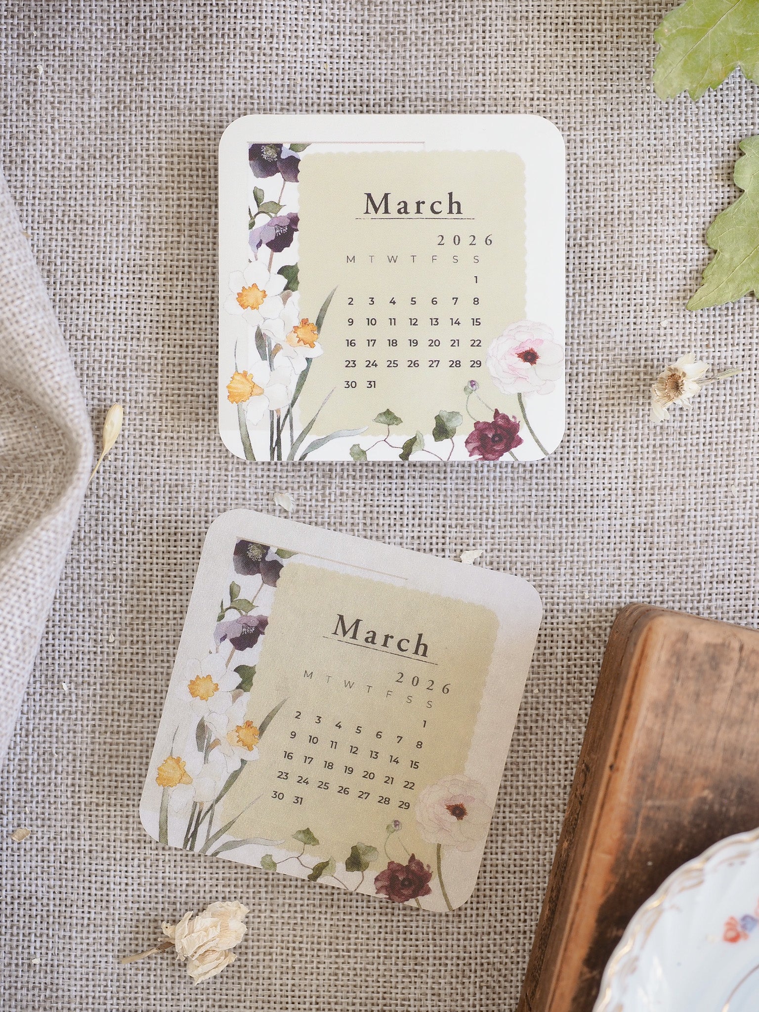 Decorative March 2026 calendar showing a soft floral and botanical theme with a muted palette of pinks, purples, and greens.