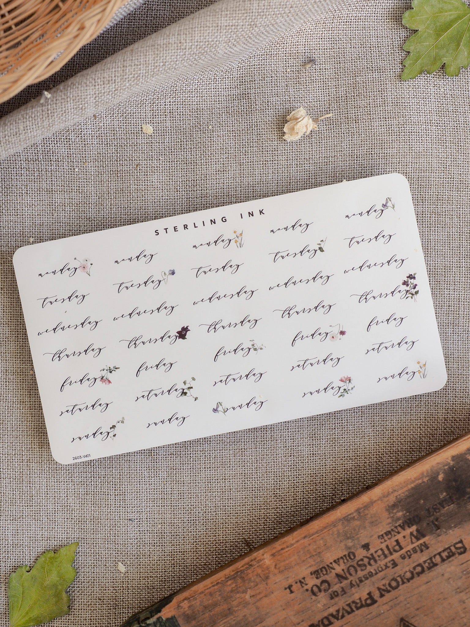Weekly sticker sheet featuring the days of the week and decorative watercolor floral accents in soft pink and brown tones for planner decorating.