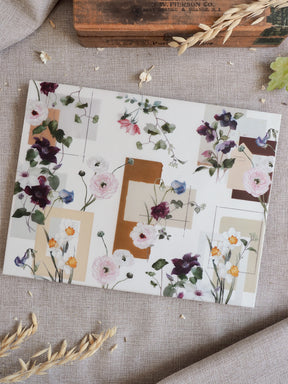 Watercolor floral pattern featuring soft blush, lilac, and cream blooms set against a modern, structured grid of neutral tan and ivory geometric blocks.