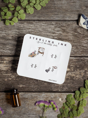 A set of six white monthly planner tabs featuring coordinating vintage clock and timepiece illustrations, perfect for tracking April 2025.