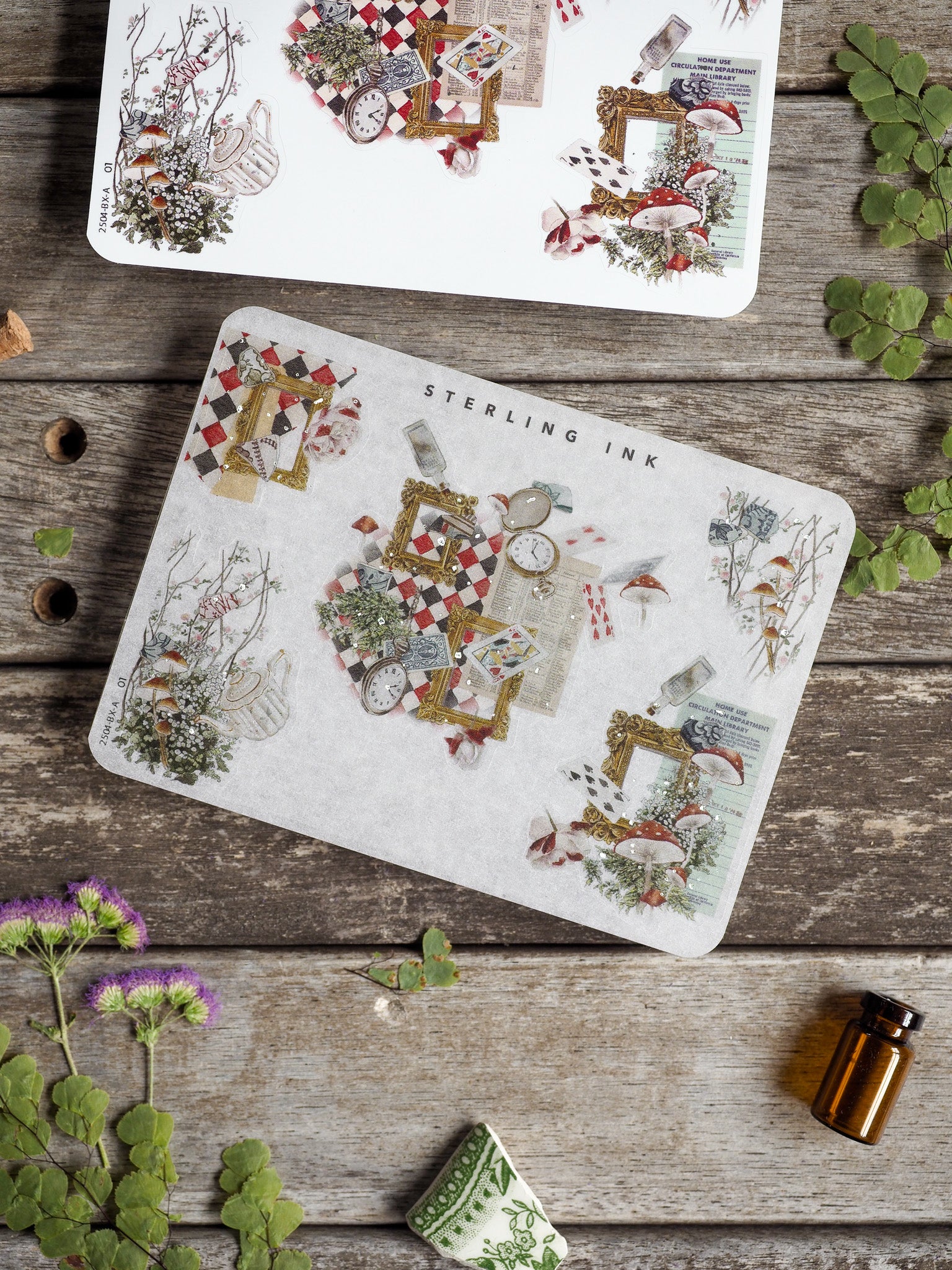 Vintage decorative sticker sheets featuring botanical vignettes, ornamental picture frames, and antique elements accented with shimmering silver foil.