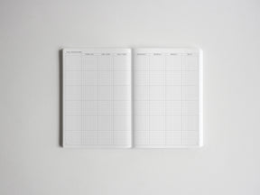 Open planner spread detailing goal breakdown, with structured grids for yearly, quarterly, monthly, weekly, and daily planning and tracking.