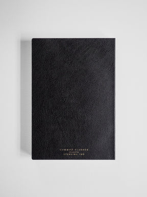 Elegant black faux leather planner with subtle textured finish, featuring centered metallic branding and the academic year designation.