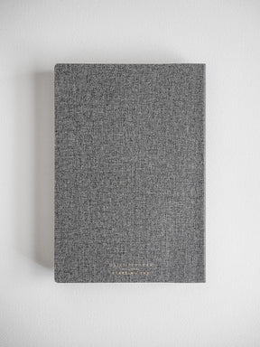 Textured, dark charcoal gray academic daily planner with a solid, uniform cover, suitable for year-long academic planning.