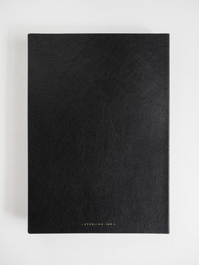 A black textured notebook or journal with a minimalist design, featuring the brand name 'STERLING INK' in small gold lettering at the bottom center, displayed on a clean white background.
#Color_Onyx
