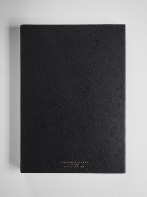 A sophisticated black B5 academic planner with a textured cover and elegantly embossed gold lettering for "Common Planner."