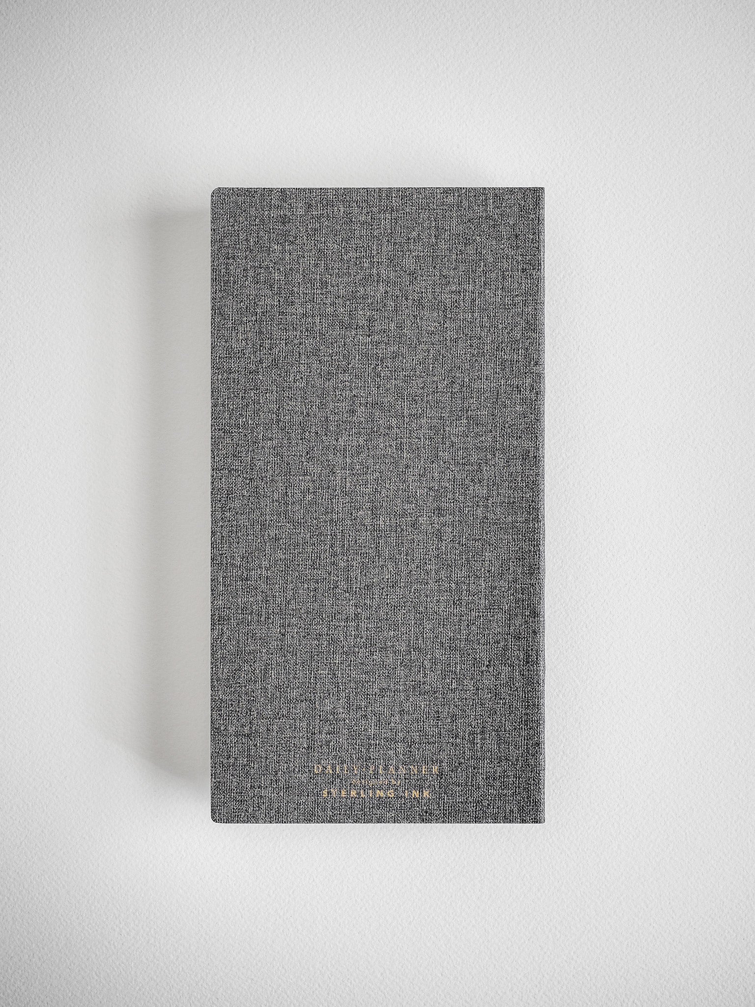 Textured, dark charcoal gray daily planner featuring subtle academic branding for the 2026-2027 academic year.