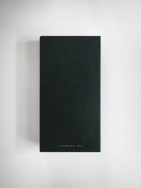 A tall, dark green textured leather journal or notebook with gold foil text reading 'STERLING INK.' at the bottom, displayed against a neutral light gray background.
#Color_Forest