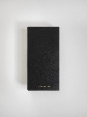 A black textured leather notebook or journal with gold foil text at the bottom reading 'STERLING, INK.', photographed flat against a light gray background.
#Color_Onyx