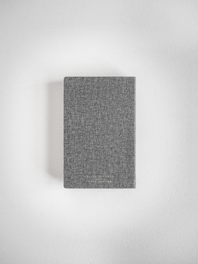 Pocket daily academic planner featuring a dark gray, subtly textured woven cover, designed for full-year scheduling and organization.