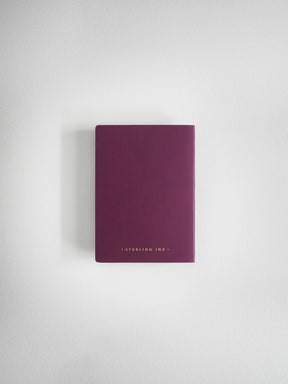 A slim, matte dark purple notebook or journal with gold foil text reading 'STERLING HINE' at the bottom, centered against a light gray textured background.
#Color_Mulberry